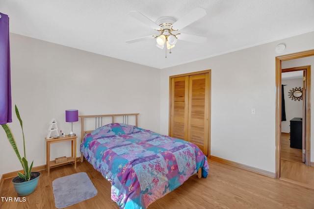 bedroom featuring a closet, ceiling fan, baseboards, and wood finished floors