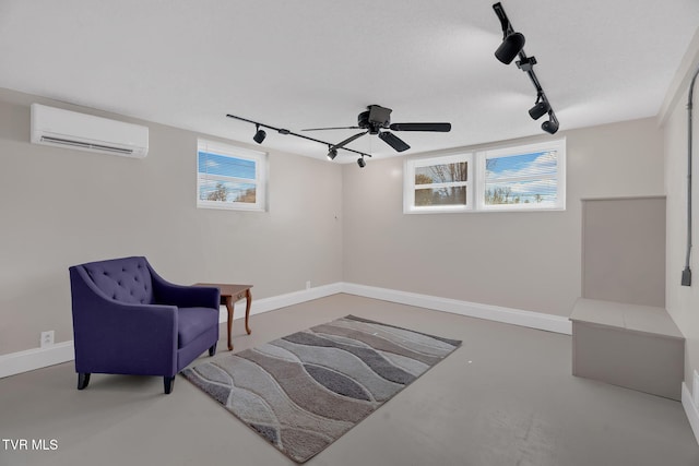 living area with concrete flooring, baseboards, and a wall mounted AC