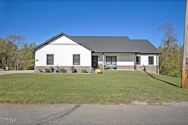 modern inspired farmhouse featuring brick siding and a front lawn