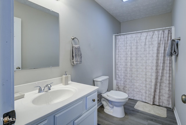 bathroom featuring a shower with shower curtain, a textured ceiling, toilet, and wood finished floors