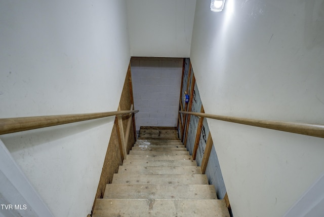 staircase with concrete block wall