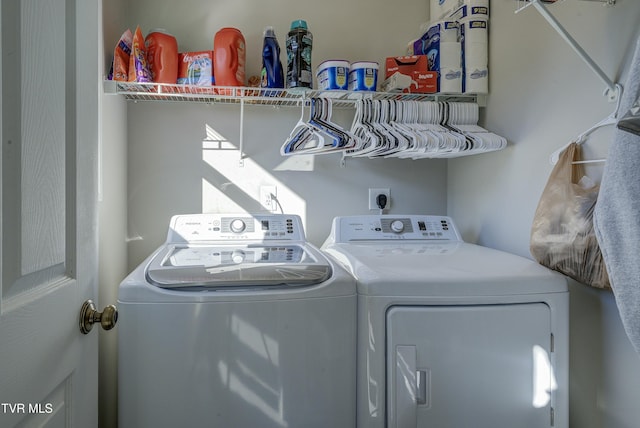 clothes washing area featuring laundry area and washer and clothes dryer