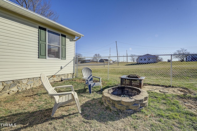 view of yard featuring an outdoor fire pit and fence