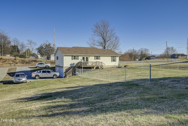 exterior space featuring a garage, fence, and a front lawn