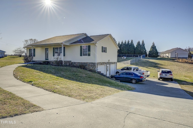 view of front facade with stone siding, an attached garage, driveway, and a front lawn