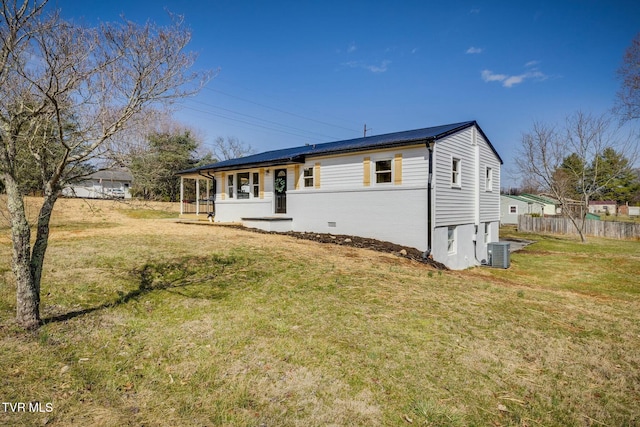 view of front of house featuring brick siding, fence, a front lawn, and central AC unit