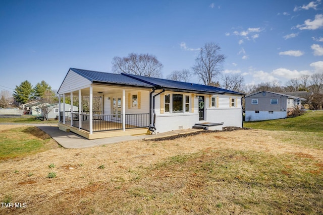 rear view of house featuring crawl space, metal roof, a porch, and a yard