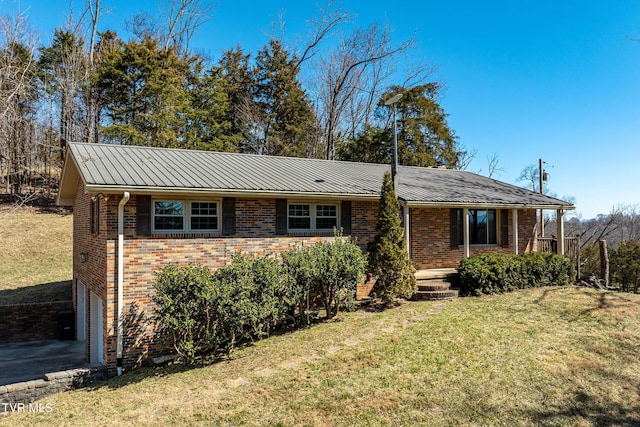 single story home featuring metal roof, brick siding, a front lawn, and an attached garage