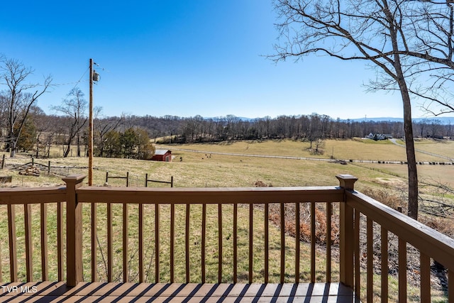 wooden deck with an outbuilding, a rural view, and a lawn