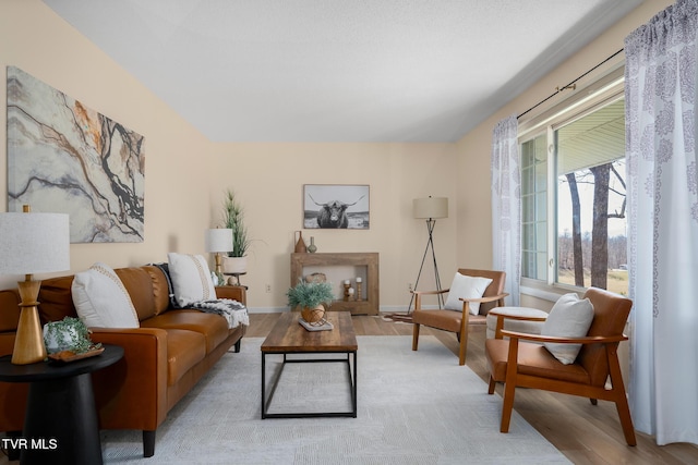 living area with light wood-type flooring and baseboards