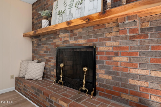 interior details with a fireplace, baseboards, and wood finished floors