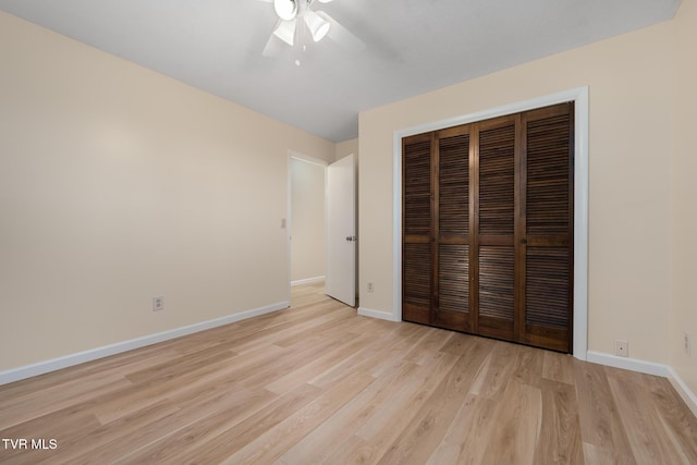 unfurnished bedroom with a ceiling fan, a closet, light wood-style flooring, and baseboards