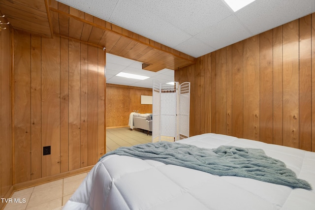 tiled bedroom with wood walls and a drop ceiling