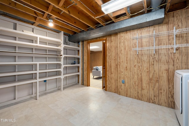 unfinished below grade area featuring washer / clothes dryer and wood walls