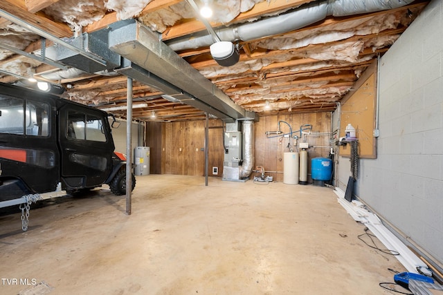 unfinished below grade area with water heater, concrete block wall, and heating unit