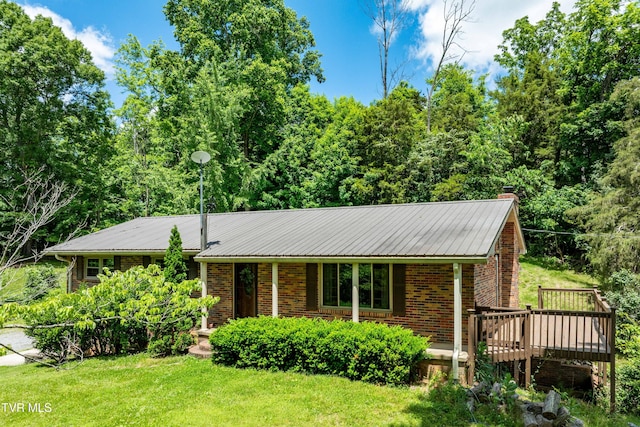 472 Harmony Rd, Jonesborough, TN 37659 - view of front of home with a chimney, brick siding, a front lawn, a wooden deck, and metal roof