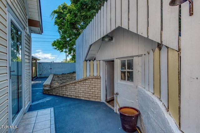 view of side of property with a patio area and fence