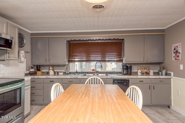 kitchen with a sink, stainless steel appliances, gray cabinets, and visible vents