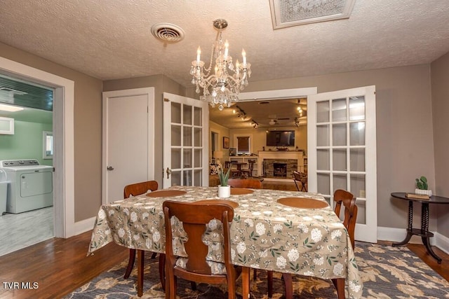 dining space with visible vents, a fireplace, baseboards, and wood finished floors