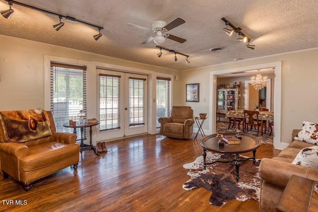 living room with a healthy amount of sunlight, ornamental molding, wood finished floors, and french doors