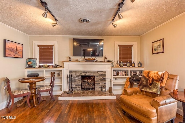 living room with visible vents, crown molding, and wood finished floors