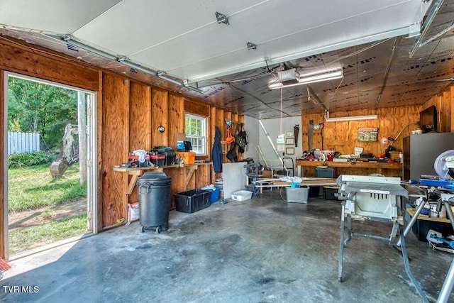 garage featuring wood walls, a workshop area, and a garage door opener