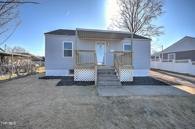 rear view of house with fence and a wooden deck