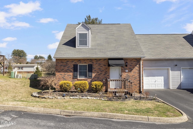 view of front facade featuring aphalt driveway, an attached garage, brick siding, and a front yard