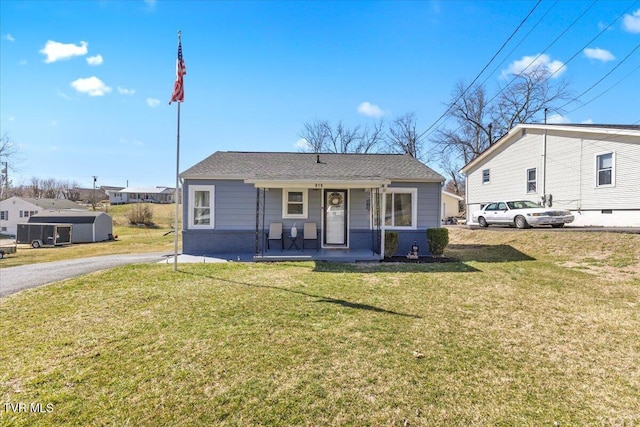 view of front of home featuring covered porch, a front lawn, and brick siding