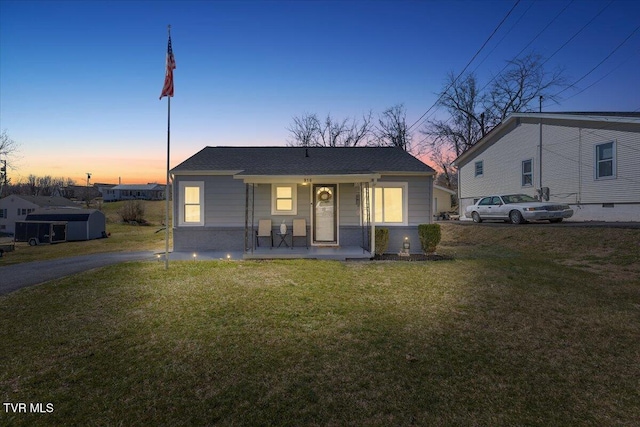 bungalow-style house with a porch and a yard