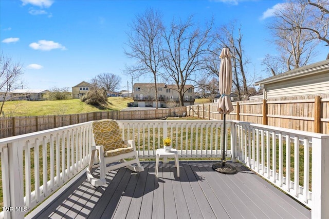 wooden terrace featuring a residential view and a fenced backyard