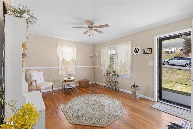 sitting room with a textured ceiling, wood finished floors, and a wealth of natural light