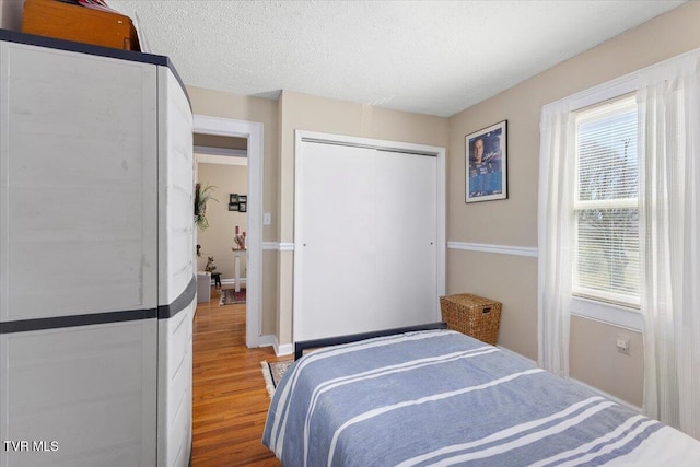 bedroom featuring a textured ceiling, a closet, and wood finished floors