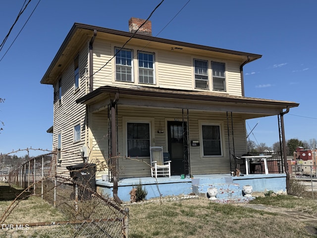 view of front of home with covered porch and a chimney