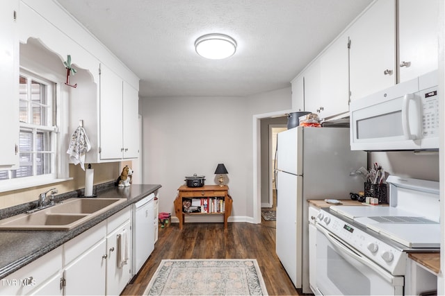 kitchen featuring a textured ceiling, white appliances, dark wood-style flooring, a sink, and white cabinets