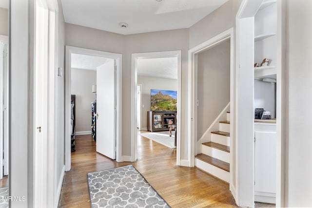 foyer entrance featuring stairway, wood finished floors, and baseboards