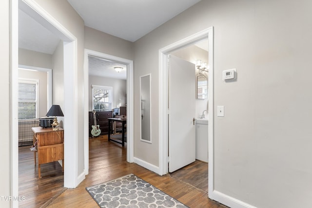 hallway with baseboards and wood finished floors