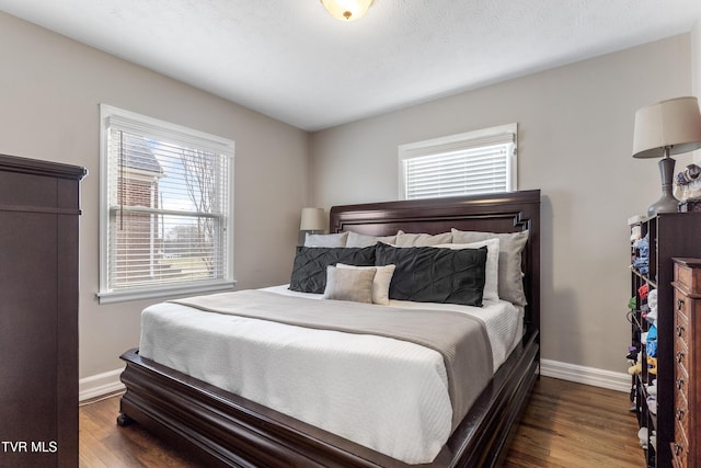 bedroom featuring a textured ceiling, wood finished floors, and baseboards