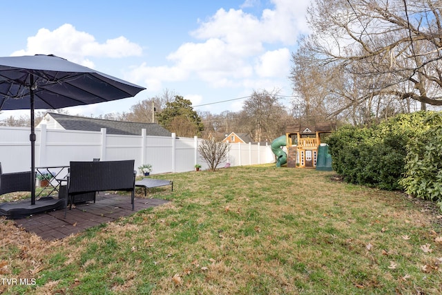 view of yard featuring a patio area, a fenced backyard, and a playground