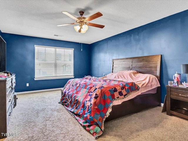 carpeted bedroom with ceiling fan, a textured ceiling, visible vents, and baseboards