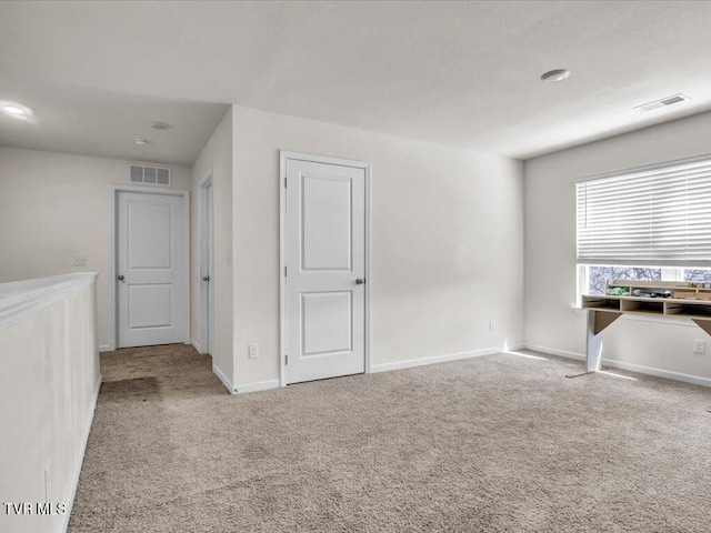 carpeted empty room with baseboards and visible vents