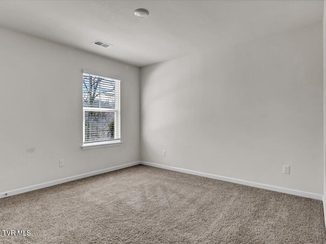 unfurnished room featuring carpet floors, visible vents, and baseboards