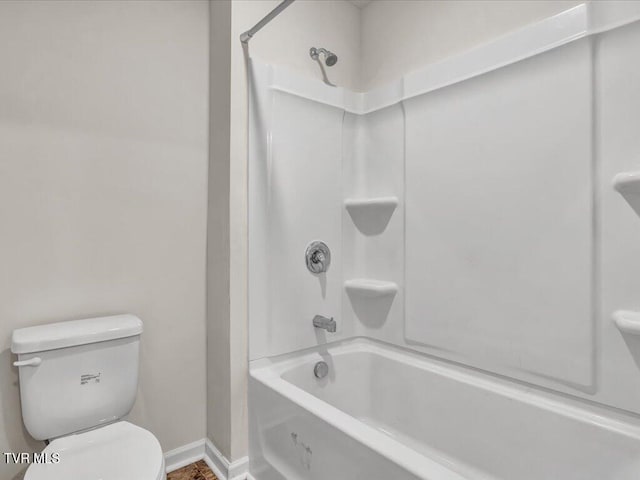 bathroom with toilet, shower / tub combination, and baseboards