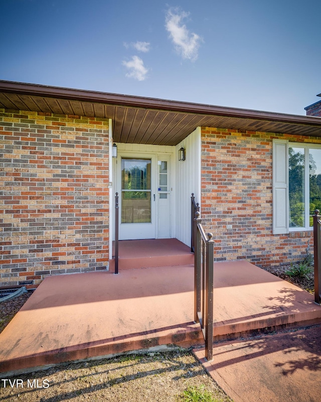 view of exterior entry with brick siding