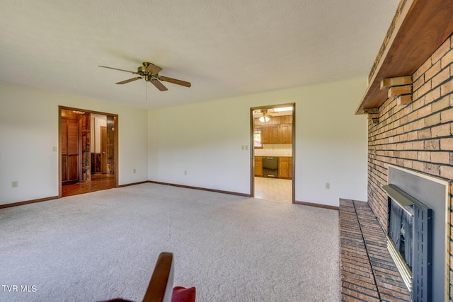 unfurnished living room featuring carpet, a fireplace, baseboards, and a ceiling fan