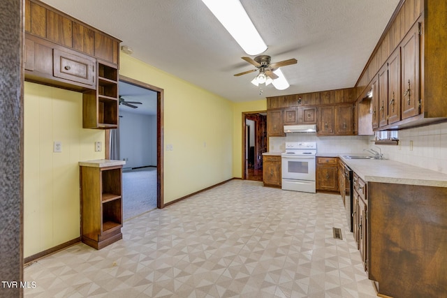 kitchen featuring electric range, light floors, light countertops, under cabinet range hood, and open shelves