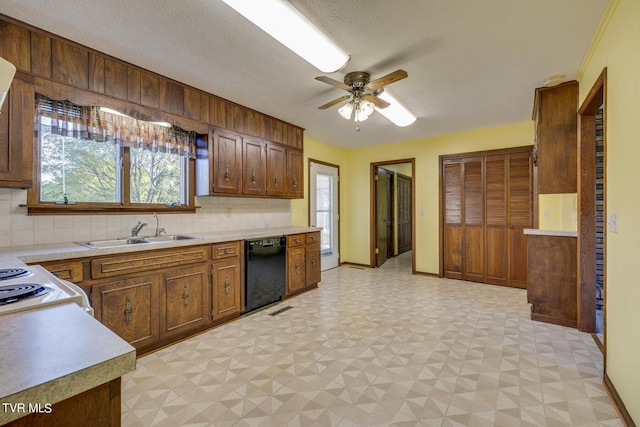 kitchen with light floors, black dishwasher, light countertops, and a sink