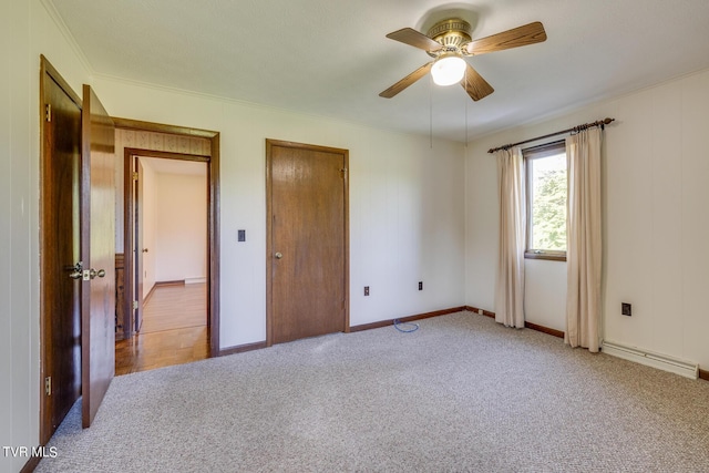 unfurnished bedroom featuring carpet, a baseboard radiator, a ceiling fan, and baseboards