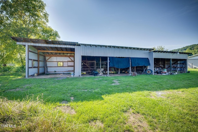 view of pole building with a carport and a lawn