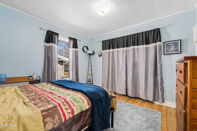 bedroom with hardwood / wood-style floors and crown molding